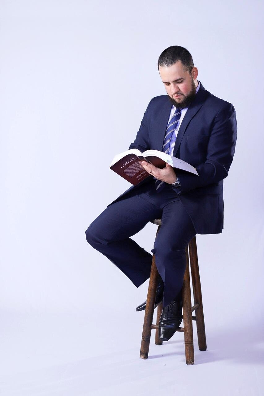 Hallan Aniello estudando um livro jurídico