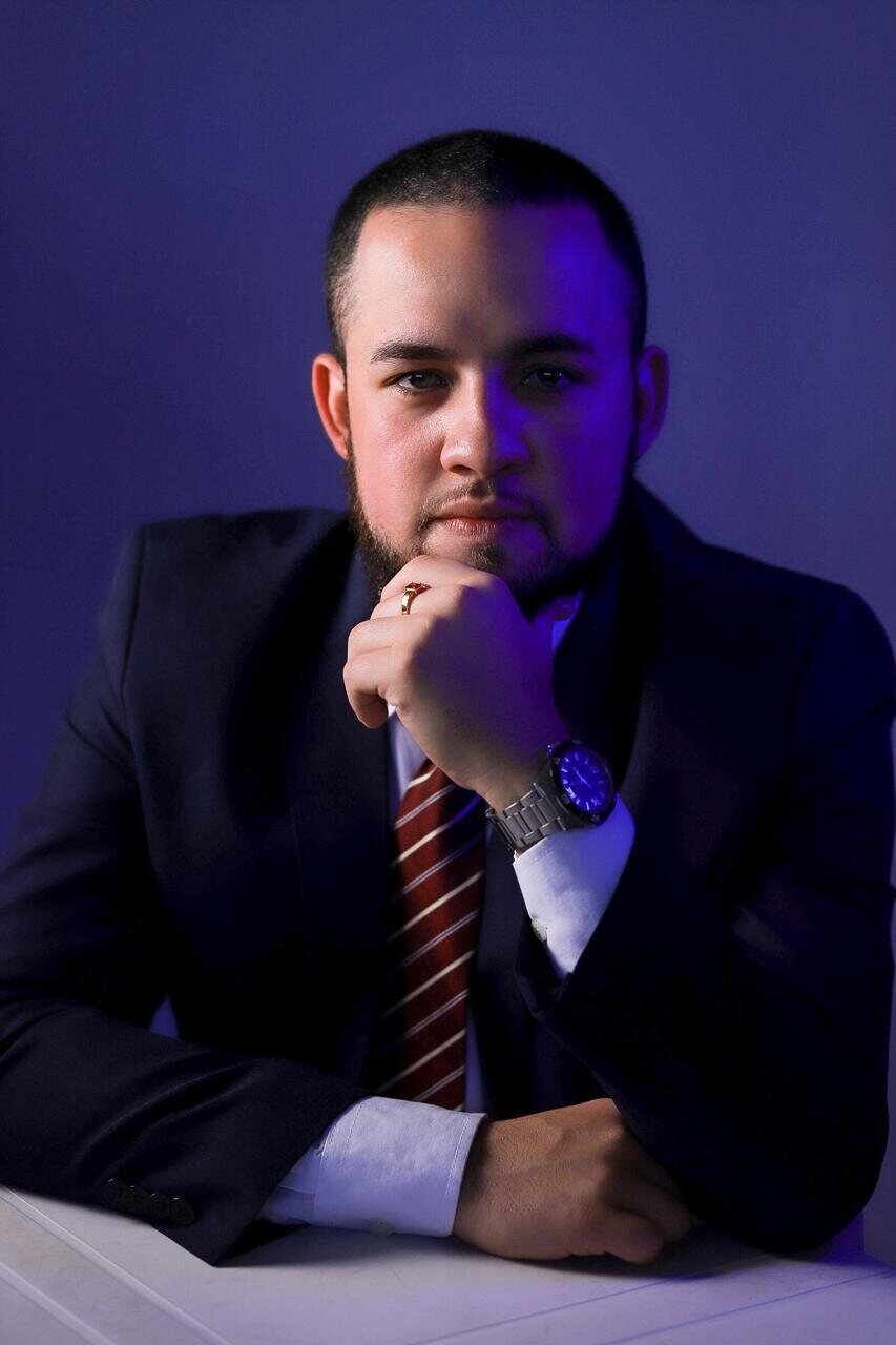 Hallan Aniello em retrato profissional no escritório